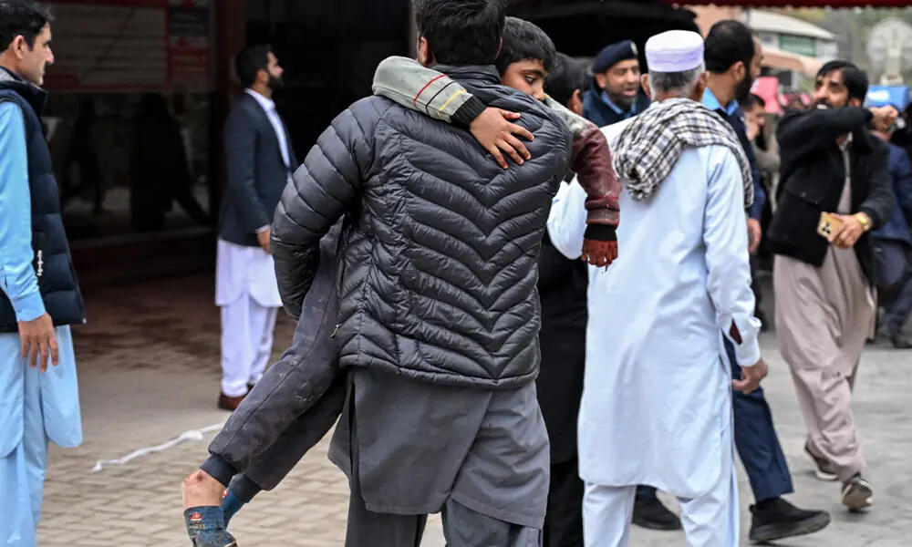 A man carries an injured boy to a hospital following an explosion at a mosque in Islamabad on February 6, 2026. Photo: AFP