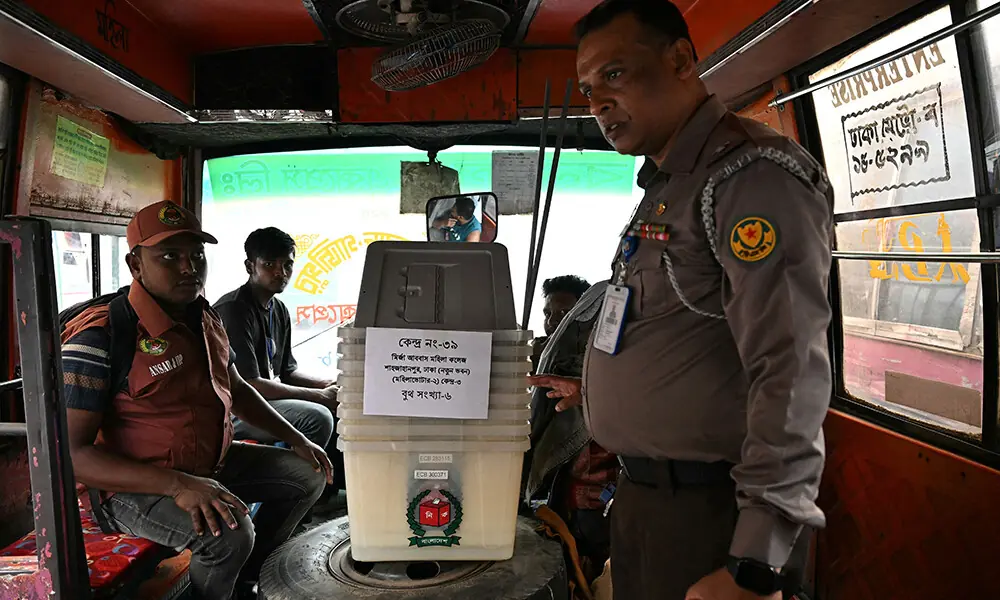 A Policeman (R) stands guard next to ballot boxes being dispatched to polling stations in Dhaka on February 11, 2026 ahead of Bangladesh&rsquo;s general elections. Photo: AFP