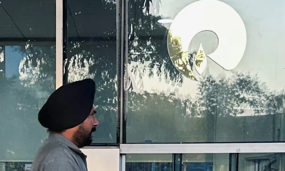 A guard walks past the Reliance Industries logo near the entrance of Dhirubhai Ambani Knowledge City in Navi Mumbai, March 15, 2024. File Photo: Reuters