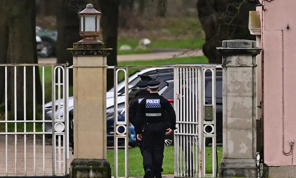 Police officers walk through the gated entrance to Royal Lodge, a 30-room property and former residence to Britain&rsquo;s former prince Andrew where police said they are still conducting a search, in Windsor, west of London on February 20, 2026, a day after Andrew Mountbatten-Windsor was arrested on the royal family&rsquo;s remote Sandringham estate in eastern England. Photo: AFP