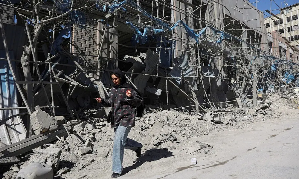 A woman walks on the street following an Israeli and US strike on a police station, amid the US-Israeli conflict with Iran, in Tehran, Iran, March 3, 2026. - Photo: Reuters