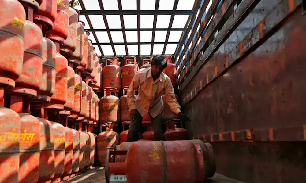A worker unloads liquefied petroleum gas (LPG) cooking cylinders from a supply truck outside a distribution centre in the western Indian city of Ahmedabad February 19, 2015. File Photo: Reuters