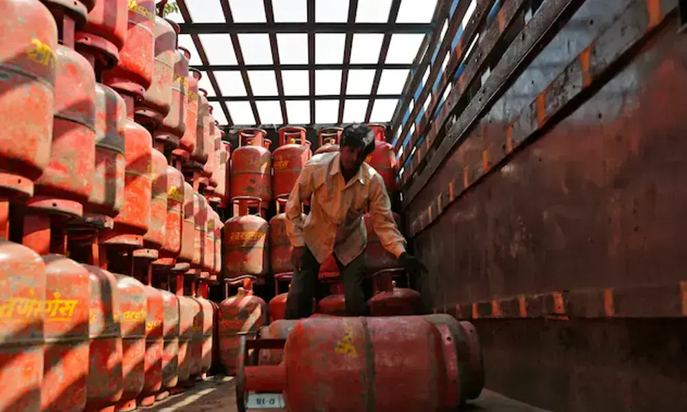 A worker unloads liquefied petroleum gas (LPG) cooking cylinders from a supply truck outside a distribution centre in the western Indian city of Ahmedabad February 19, 2015. File Photo: Reuters