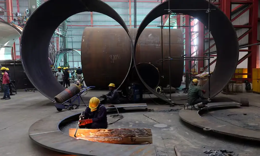A worker cuts a metal plate inside an industrial tank manufacturing factory on the outskirts of Ahmedabad, India, January 31, 2025. File Photo: Reuters