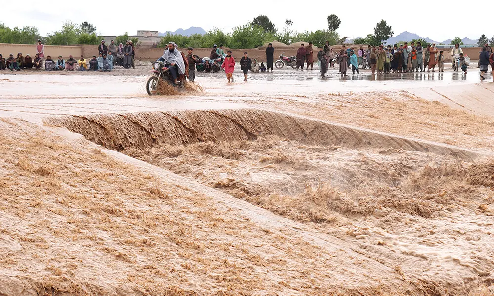 An Afghan motorist wades across a flooded road at Zawul district in Herat province on April 2, 2026. Photo: AFP