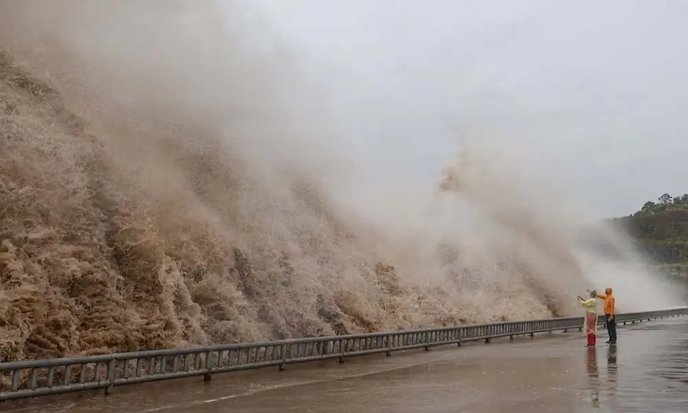 People stand next to huge waves crashing on a waterfront as Typhoon Dolphin approaches, in Sanmen County, Taizhou, Zhejiang Province, China, August 8, 2026. cnsphoto via Reuters People stand next to huge waves crashing on a waterfront as Typhoon Dolphin approaches, in Sanmen County, Taizhou, Zhejiang Province, China, August 8, 2026. cnsphoto via Reuters