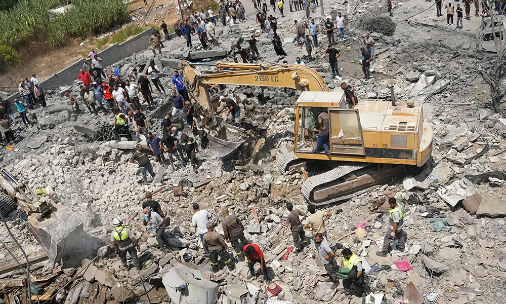 Heavy machinery, first aid responders and residents search the site of an Israeli airstrike that targeted a neighbourhood in the southern Lebanese village of Deir al-Zahrani on August 15, 2026. Photo: AFP