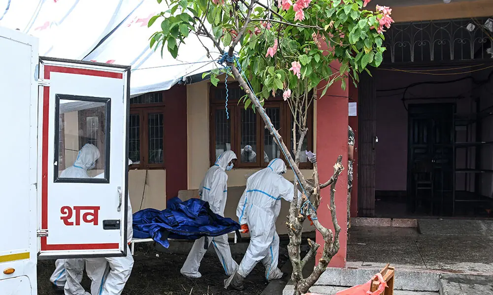 Health workers carry a dead body inside a mortuary in the aftermath of flash floods, in Bharatpur of Nepal's Chitwan district on August 30, 2026. Photo: AFP