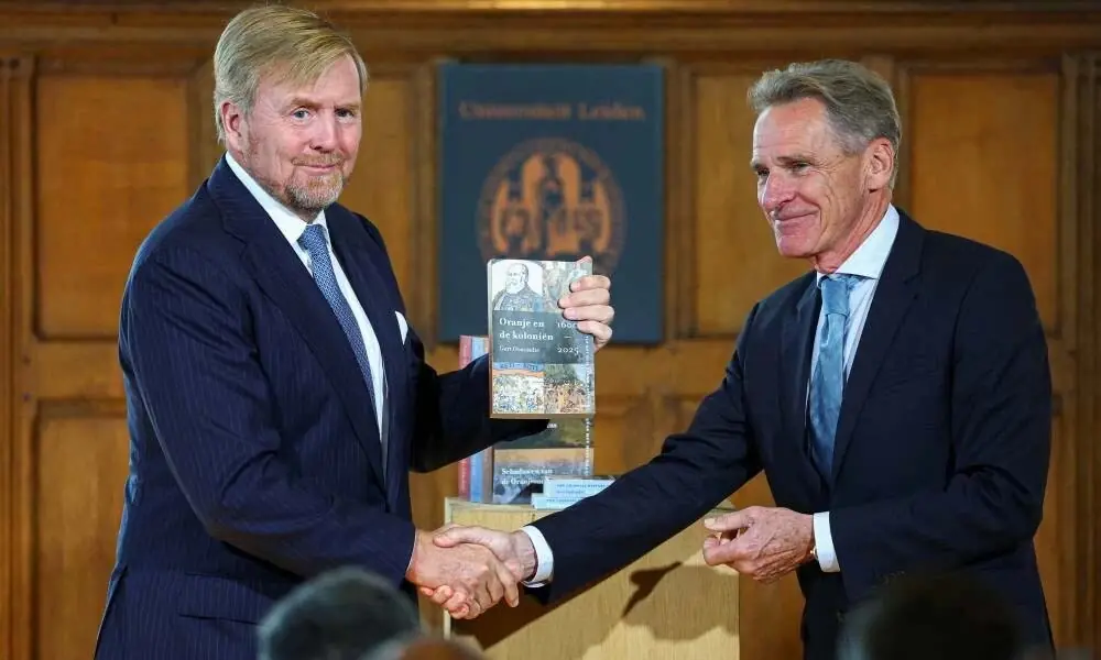 Prof. Dr. Gert Oostindie presents a volume of an independent study into the role of the House of Orange-Nassau in Dutch colonial history to Dutch King Willem-Alexander, with the study's other volumes visible, at the Academy Building of Leiden University in Leiden, Netherlands, October 2, 2026. Reuters Prof. Dr. Gert Oostindie presents a volume of an independent study into the role of the House of Orange-Nassau in Dutch colonial history to Dutch King Willem-Alexander, with the study's other volumes visible, at the Academy Building of Leiden University in Leiden, Netherlands, October 2, 2026. Reuters