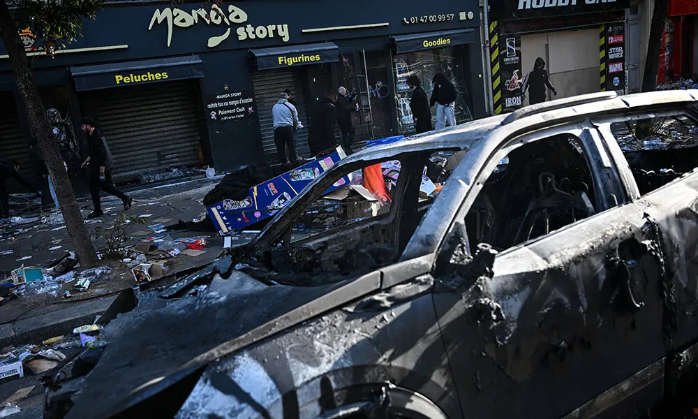A shopkeeper clears up in front of his damaged shop in Paris on October 18, 2026 a day after a nationwide protests against the "high cost of living". Photo: AFP A shopkeeper clears up in front of his damaged shop in Paris on October 18, 2026 a day after a nationwide protests against the "high cost of living". Photo: AFP