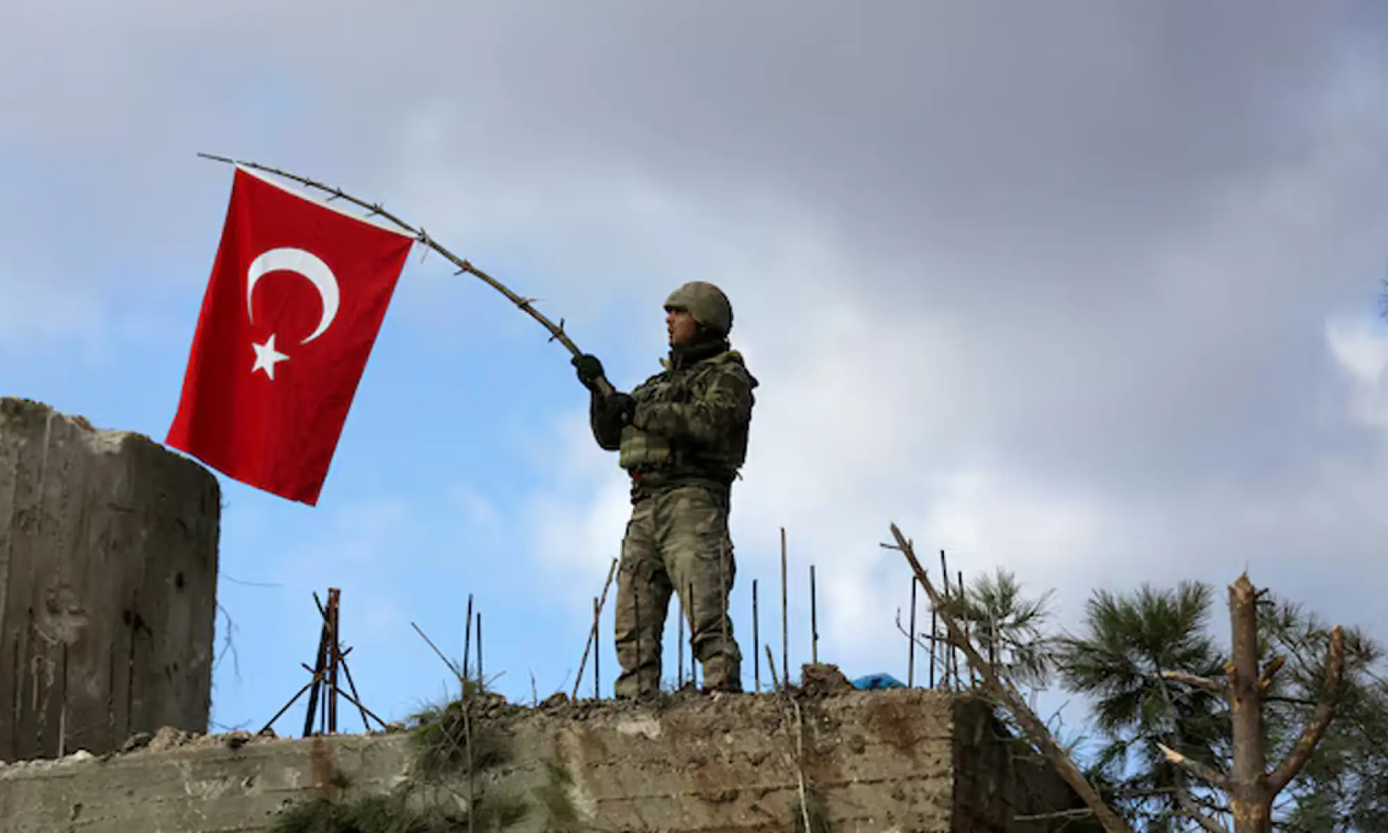 A Turkish soldier waves a flag on Mount Barsaya, northeast of Afrin, Syria January 28 ,2018. Photo: REUTERS